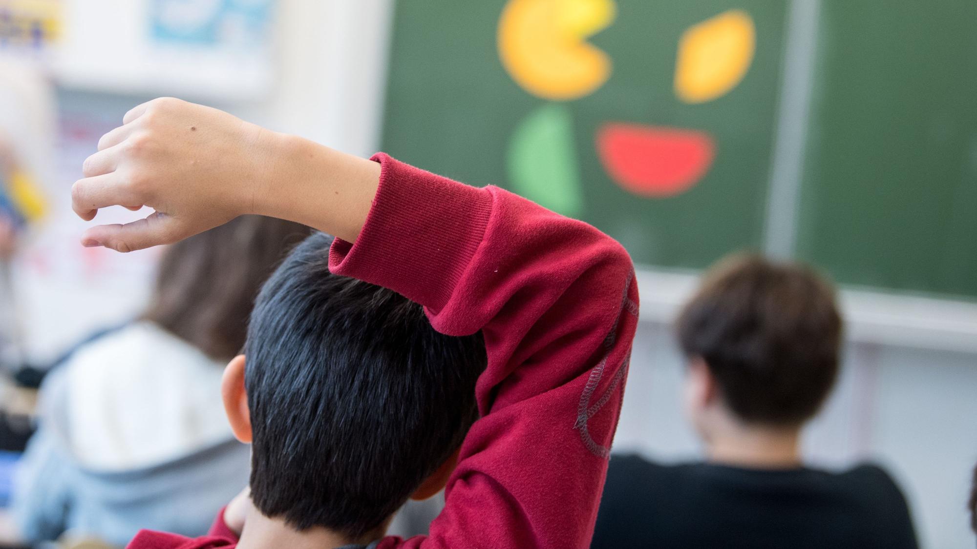 Ein Schüler meldet sich während einer Unterichtsstunde.