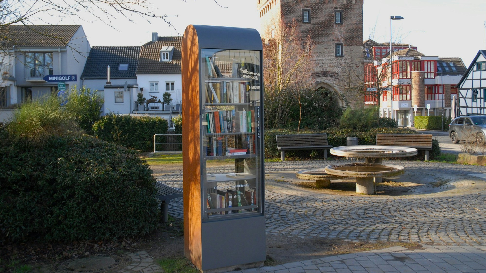 Zu sehen ist ein Bücherschrank auf einem Platz.