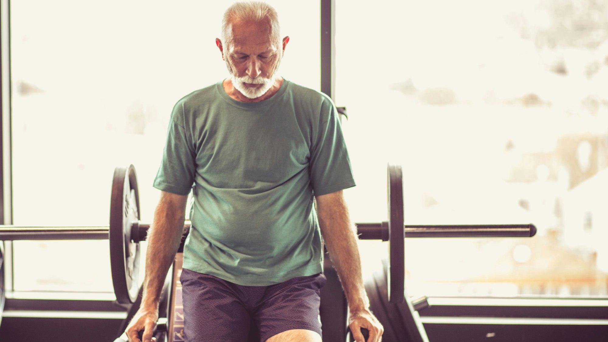 Ein älterer Mann macht Kraftübungen im Fitnessstudio.