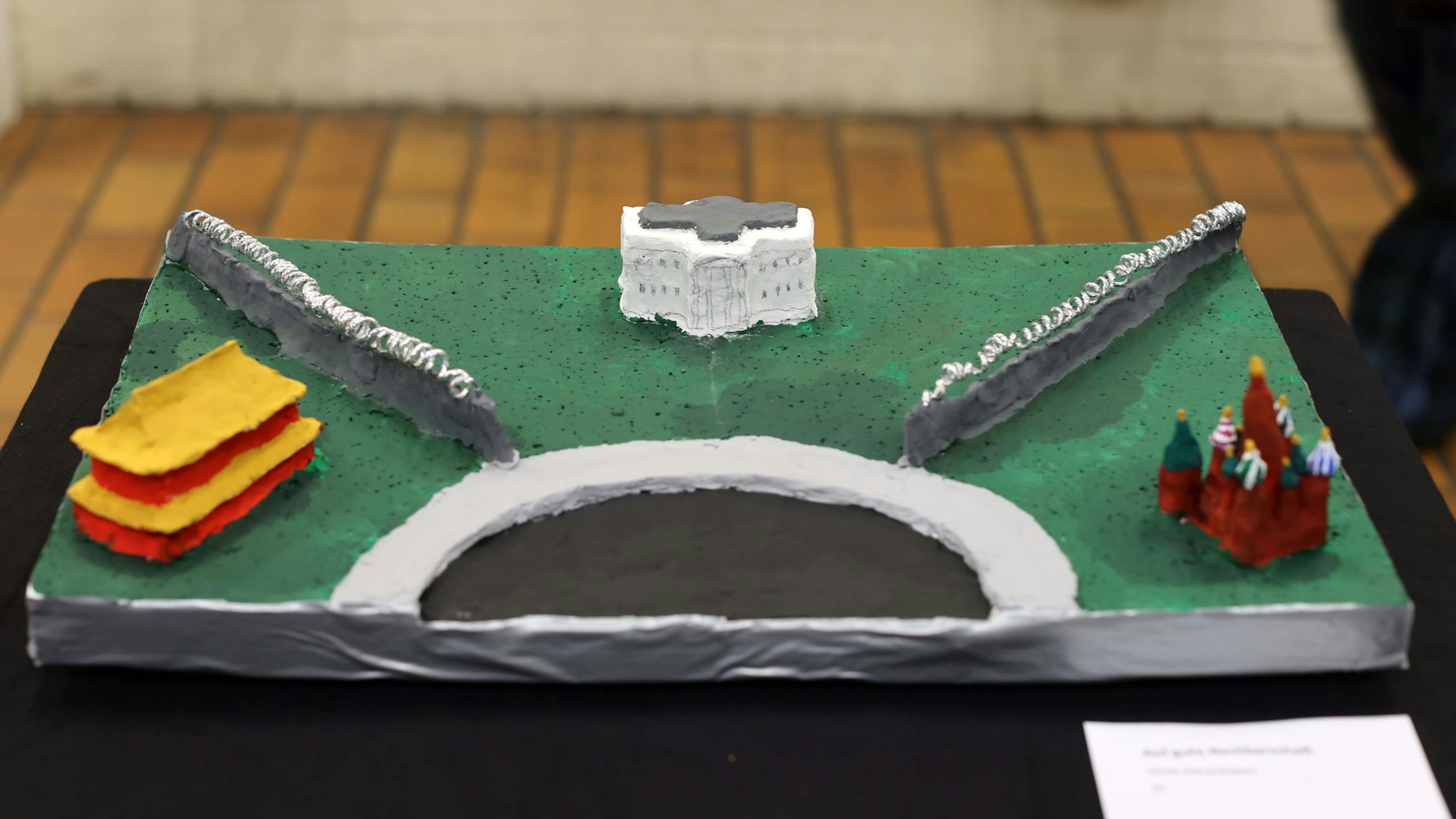 Eine Plastik mit drei Gebäuden und Mauern, die die Trennung der Weltmächte symbolisiert.