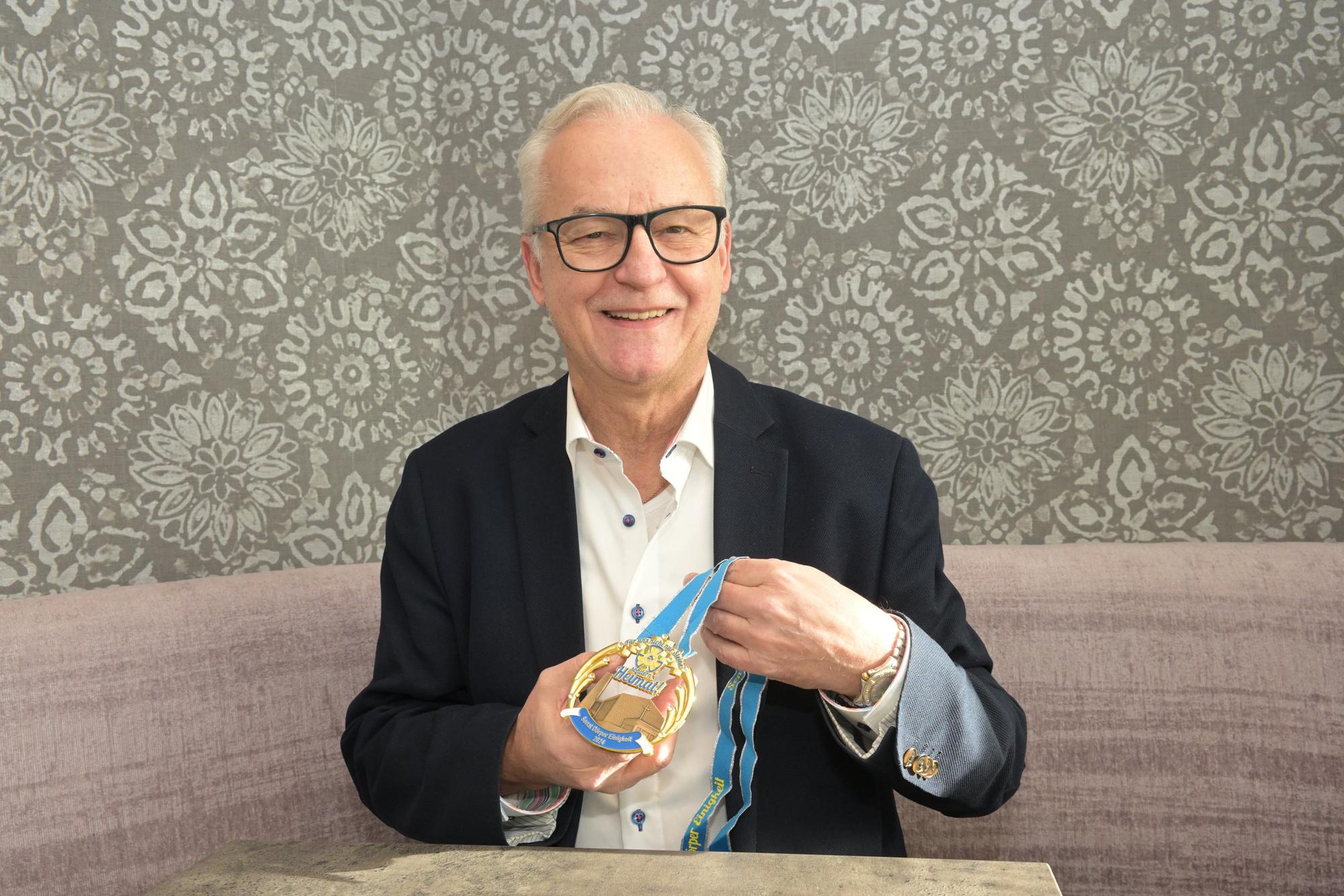 Karl-Heinz Baumgartner, Senatspräsident der Dörper Einigkeit, zeigt den Orden mit der Silhouette der Christuskirche, deren Abriss beschlossen ist.