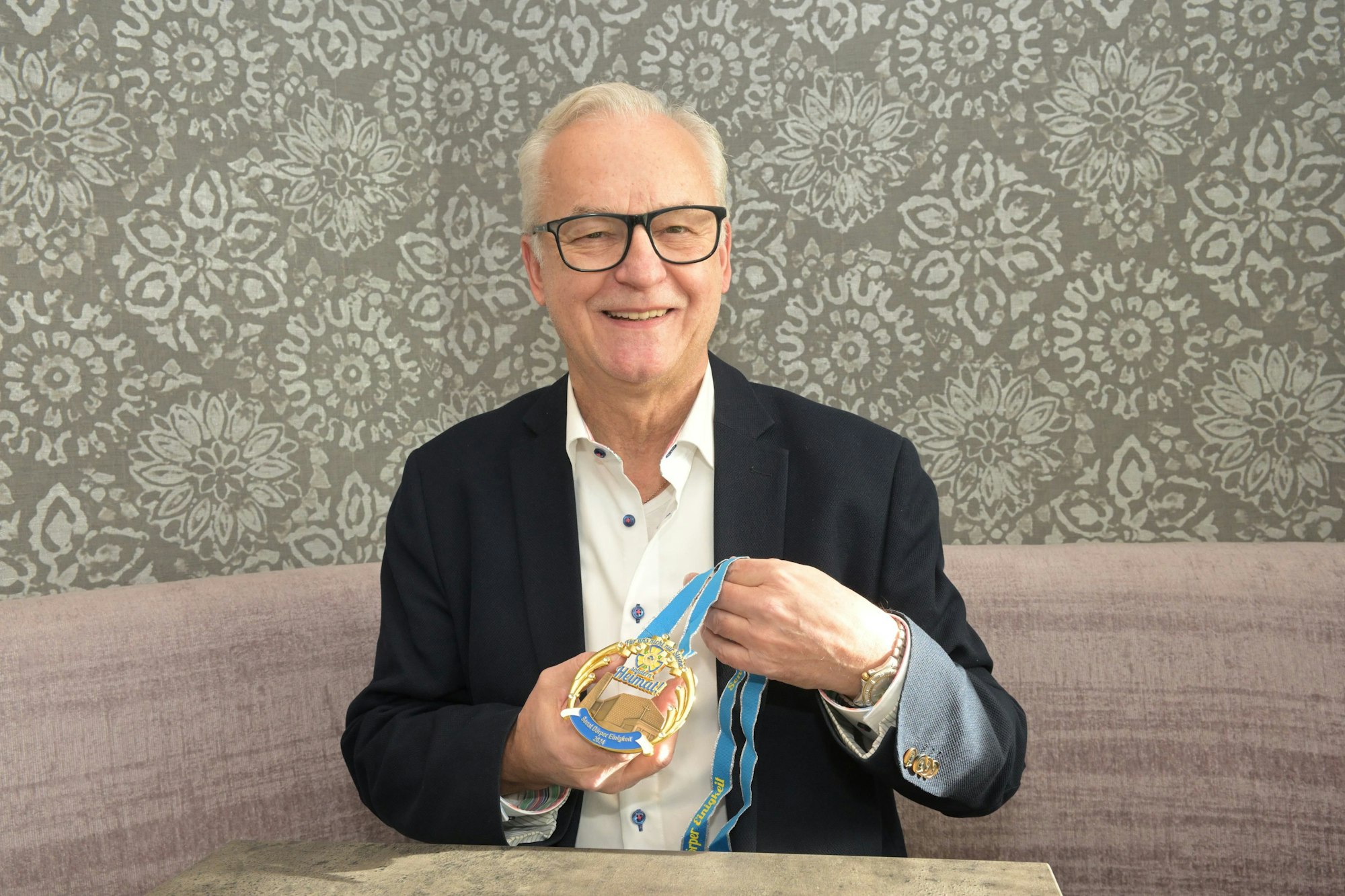 Karl-Heinz Baumgartner, Senatspräsident der Dörper Einigkeit, zeigt den Orden mit der Silhouette der Christuskirche, deren Abriss beschlossen ist.