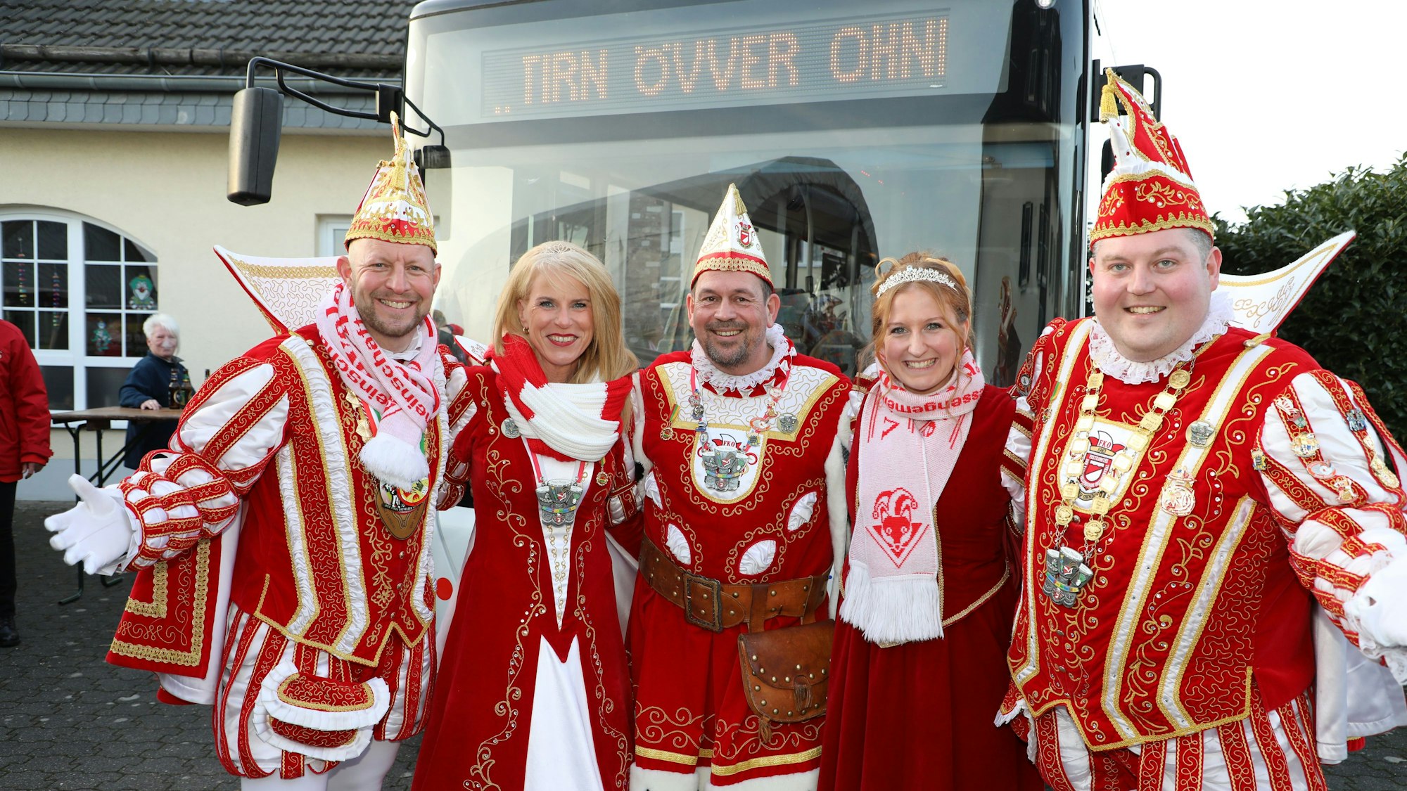 Ein Dreigestirn und ein Zweigestirn stehen vor einem Linienbus in Odenthal-Scheuren.