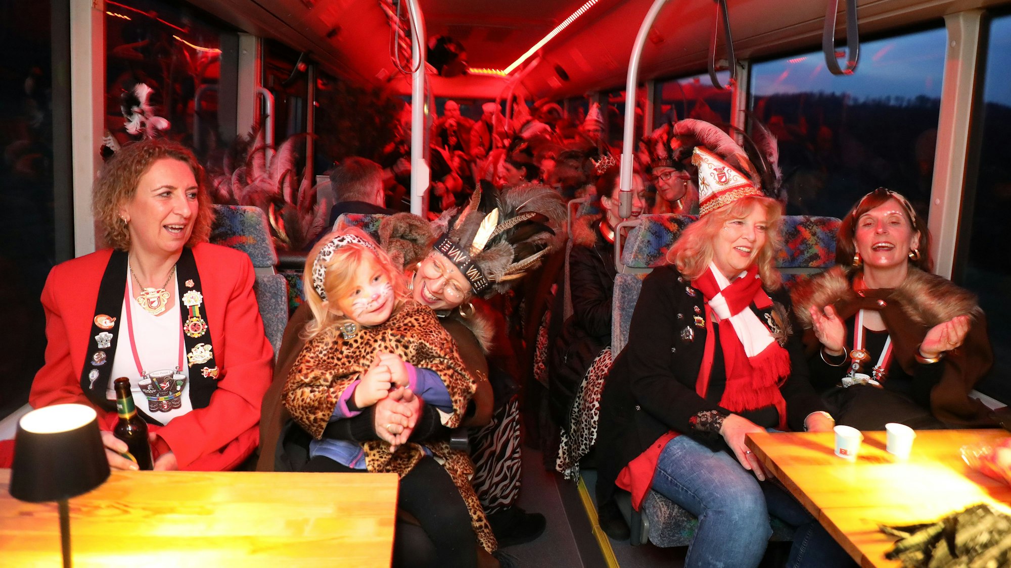 Menschen sitzen in einem Partybus und feiern.