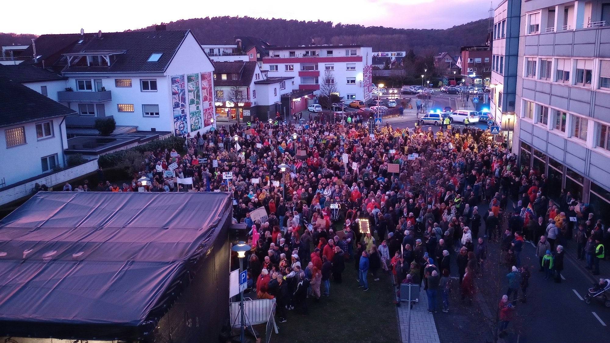 Menschen stehen vor einer Bühne.