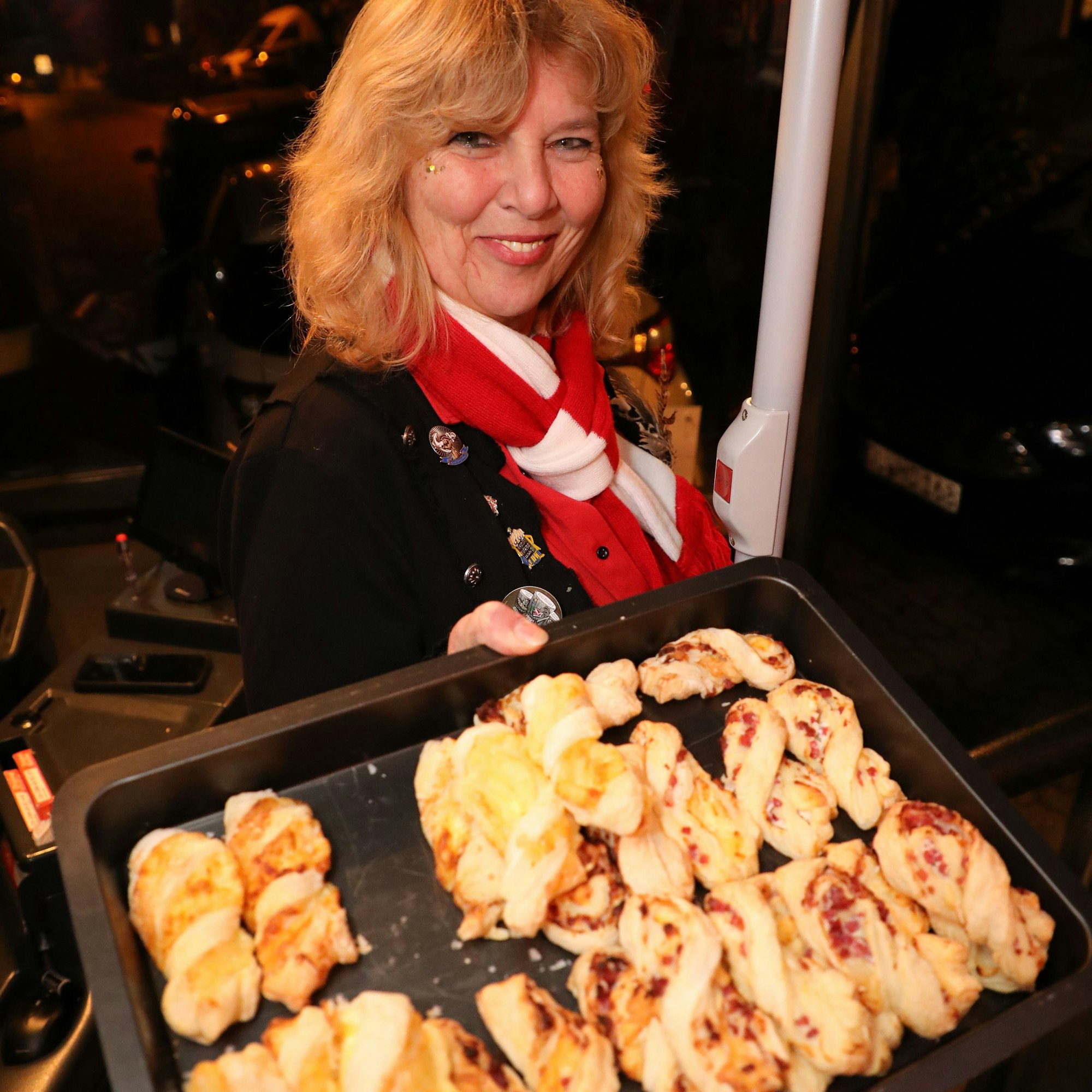 Susanne Reichmann hält ein Blech mit Backwaren.