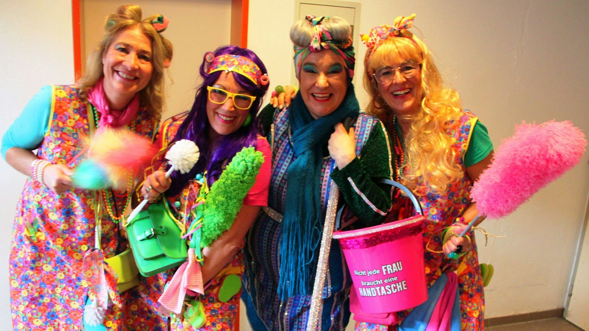Vier als Putzfrauen verkleidete Jecke stehen nebeneinander.