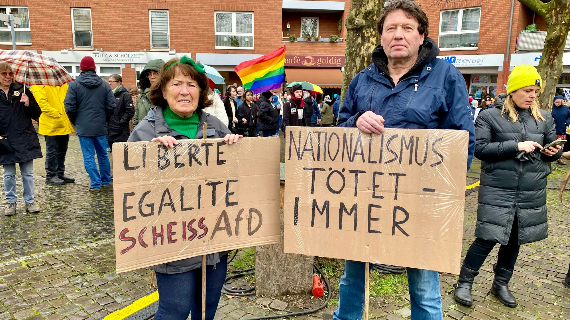 Auf dem Bild sind zwei Demonstraten mit Schildern zu sehen.