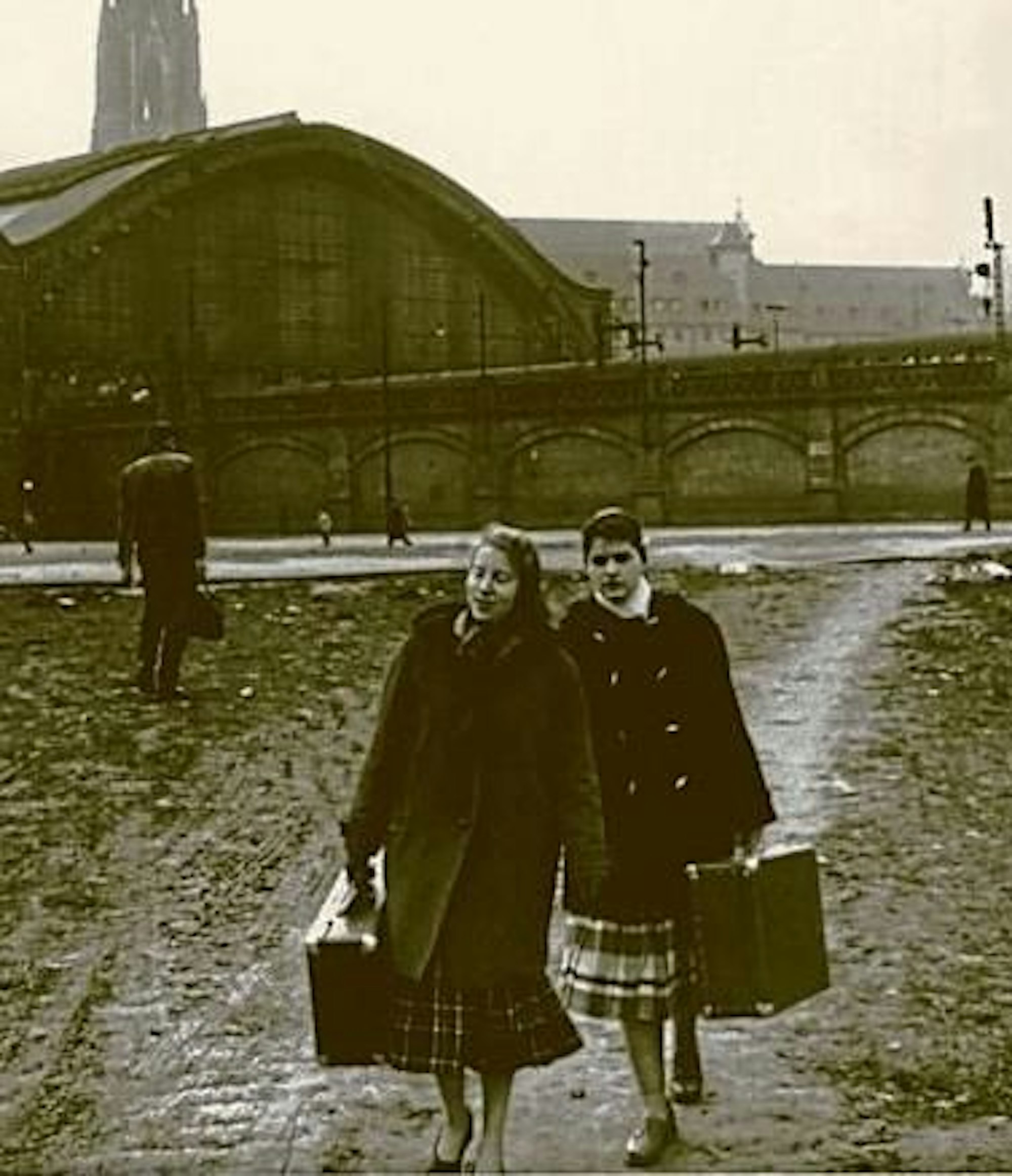 Junge Frauen vom Land mit der Hoffnung auf Arbeit gehen über den matschigen Bahnhofsvorplatz. Um 1900.