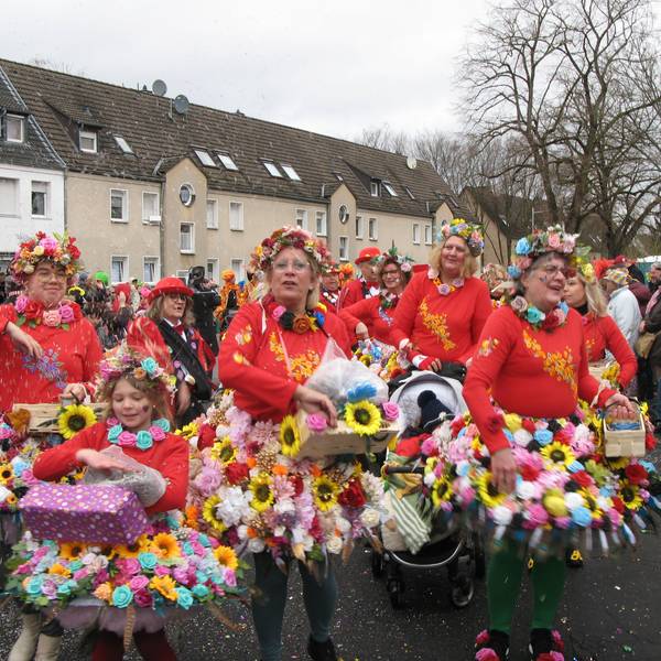 Frauen in Röcken aus bunten Blüten.