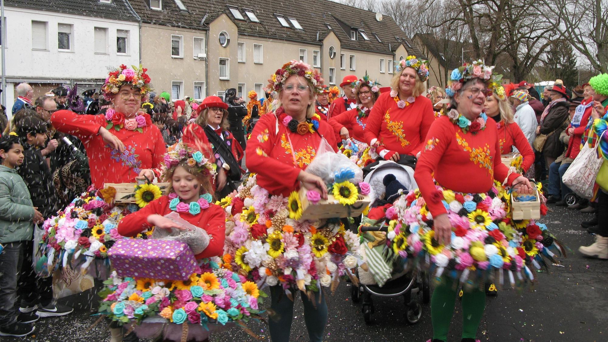 Frauen in Röcken aus bunten Blüten.
