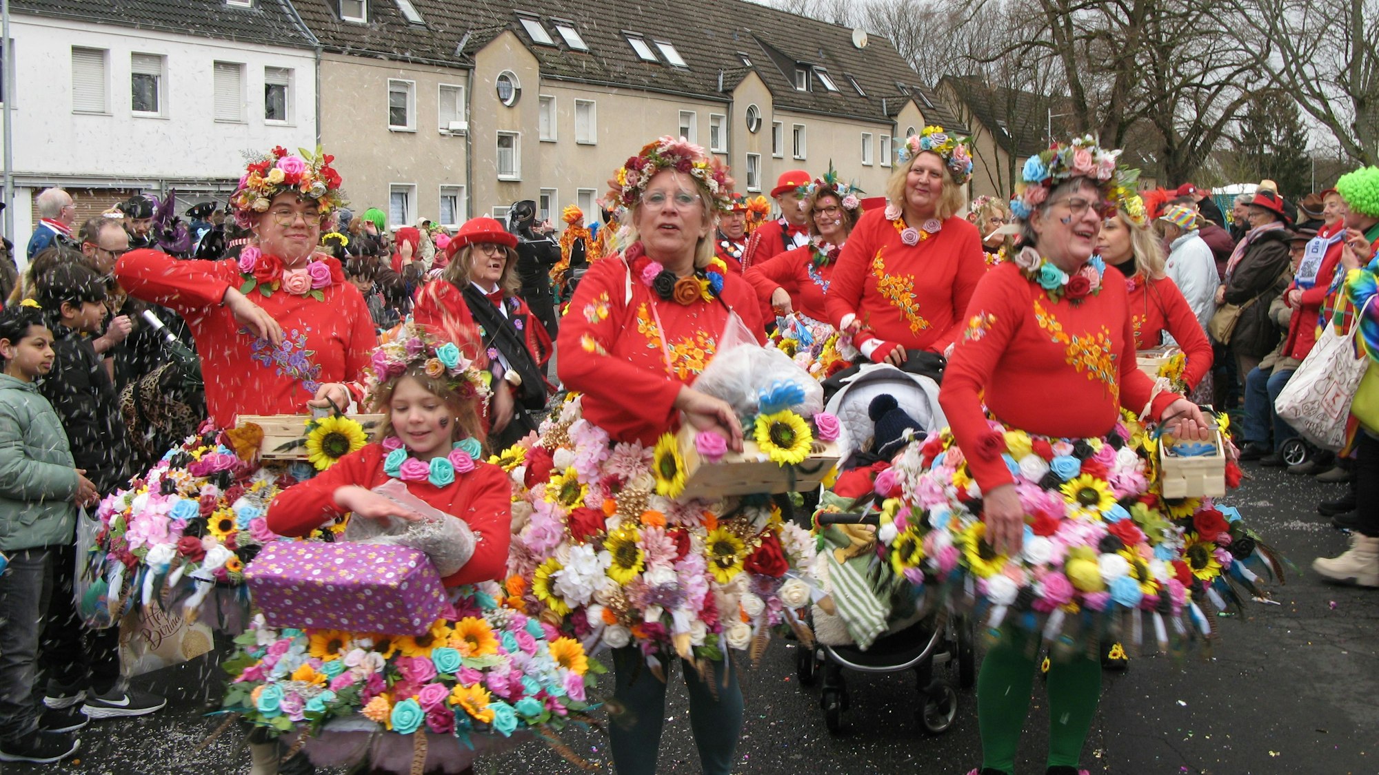 Frauen in Röcken aus bunten Blüten.
