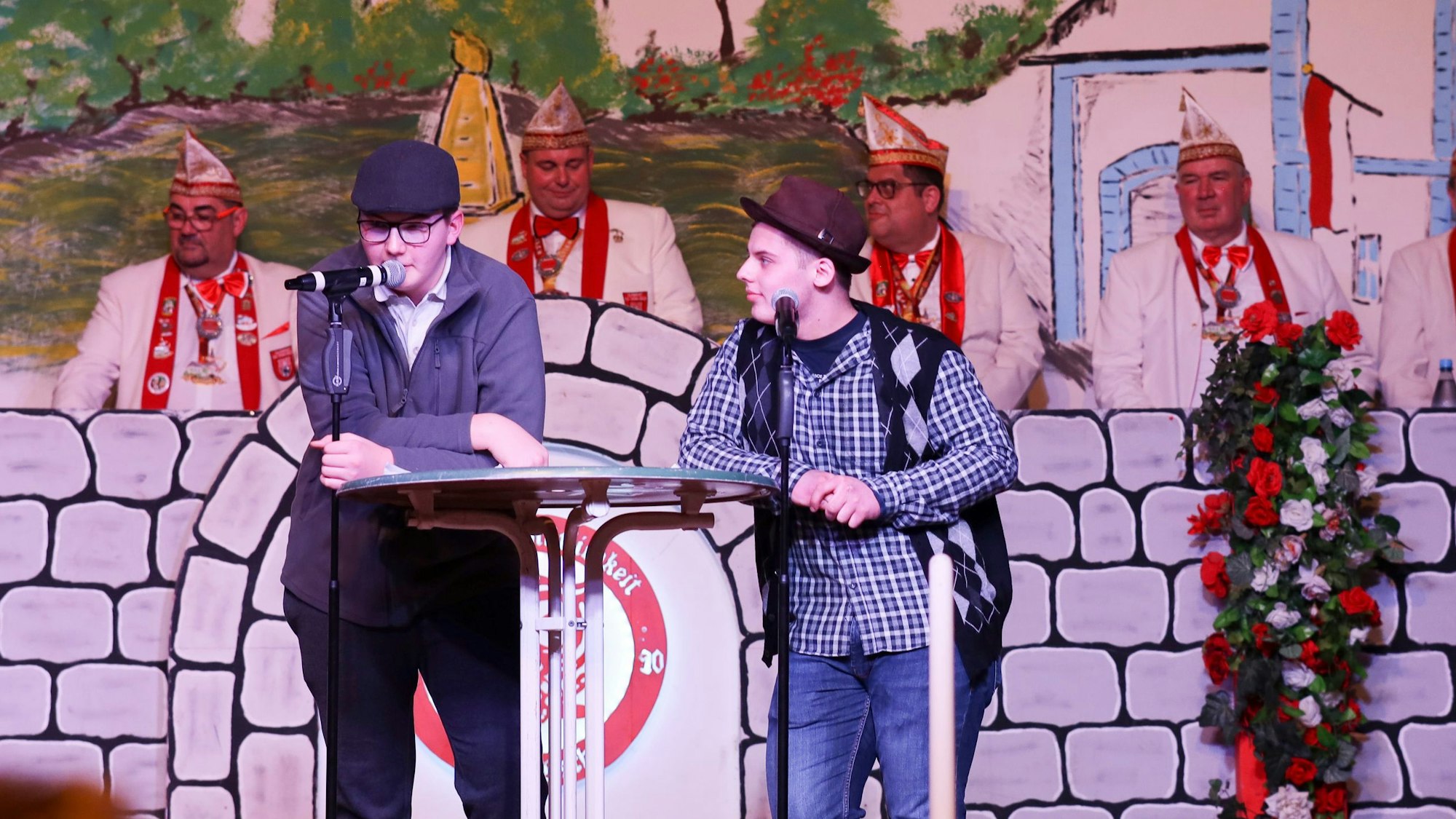 Die Jungkarnevalisten Carlo Wienand (l.) und Simon Böhmer stehen an einem Rednerpult.