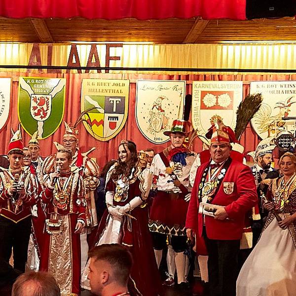 Zahlreiche Karnevalsprinzen, Prinzessinnen, Bauern und Jungfrauen stehen in ihren Kostümen auf einer Bühne.