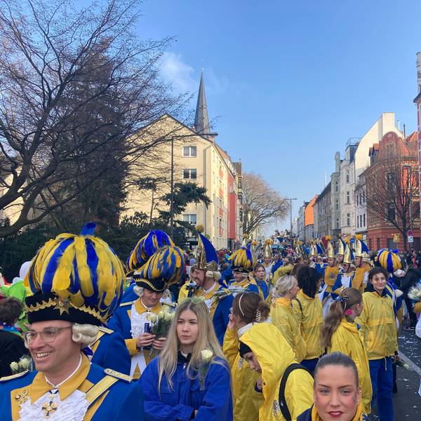 Viele Menschen tragen blau-goldene Uniformen.