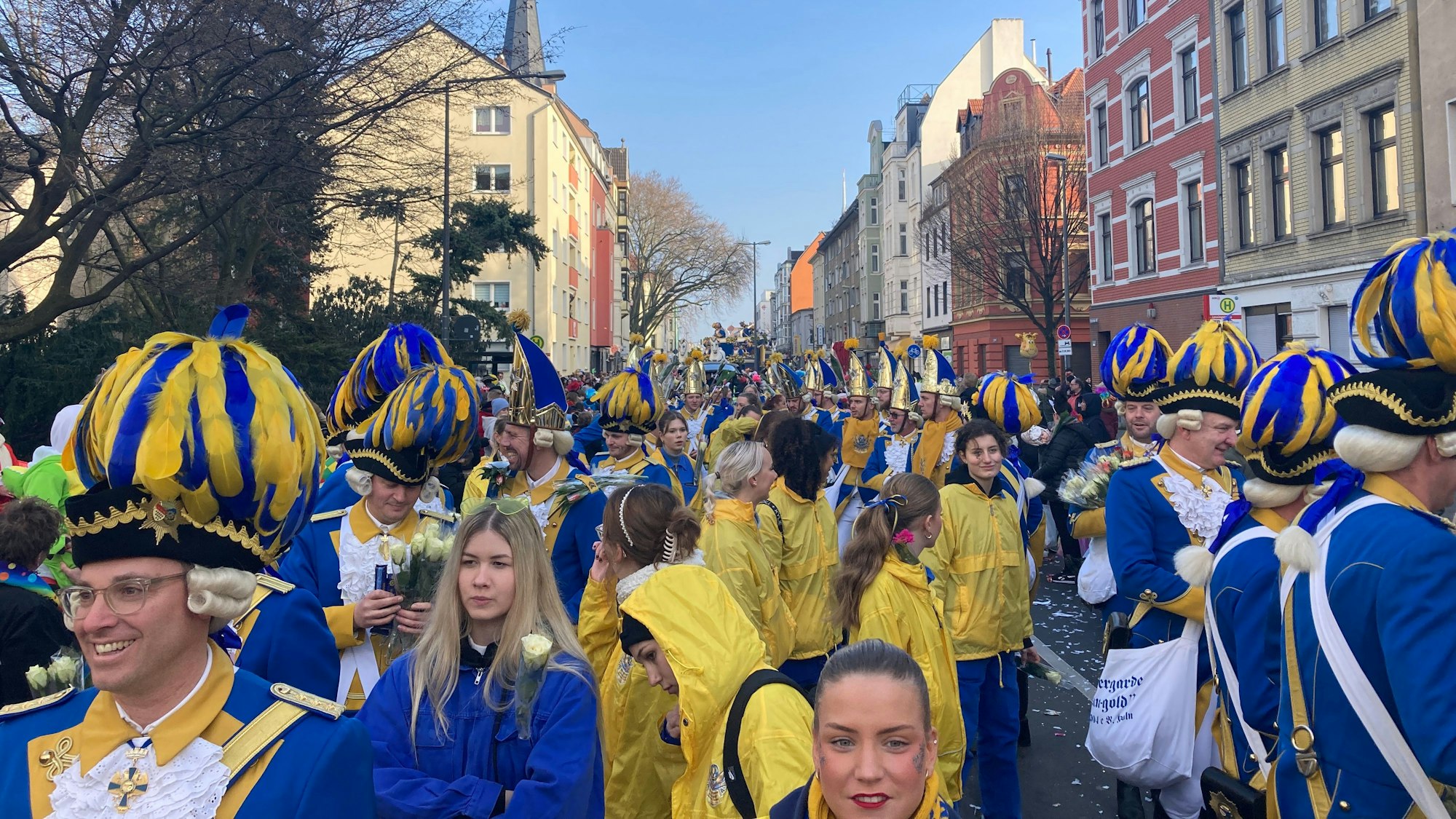 Viele Menschen tragen blau-goldene Uniformen.