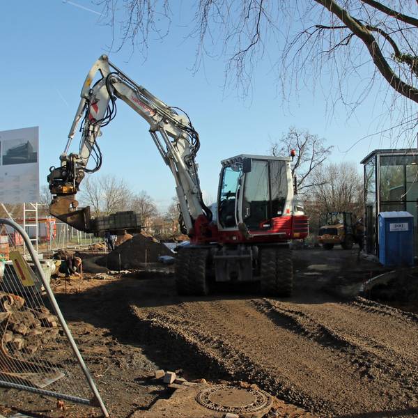 Auf dem Bild ist eine Baustelle mit Bagger zu sehen.