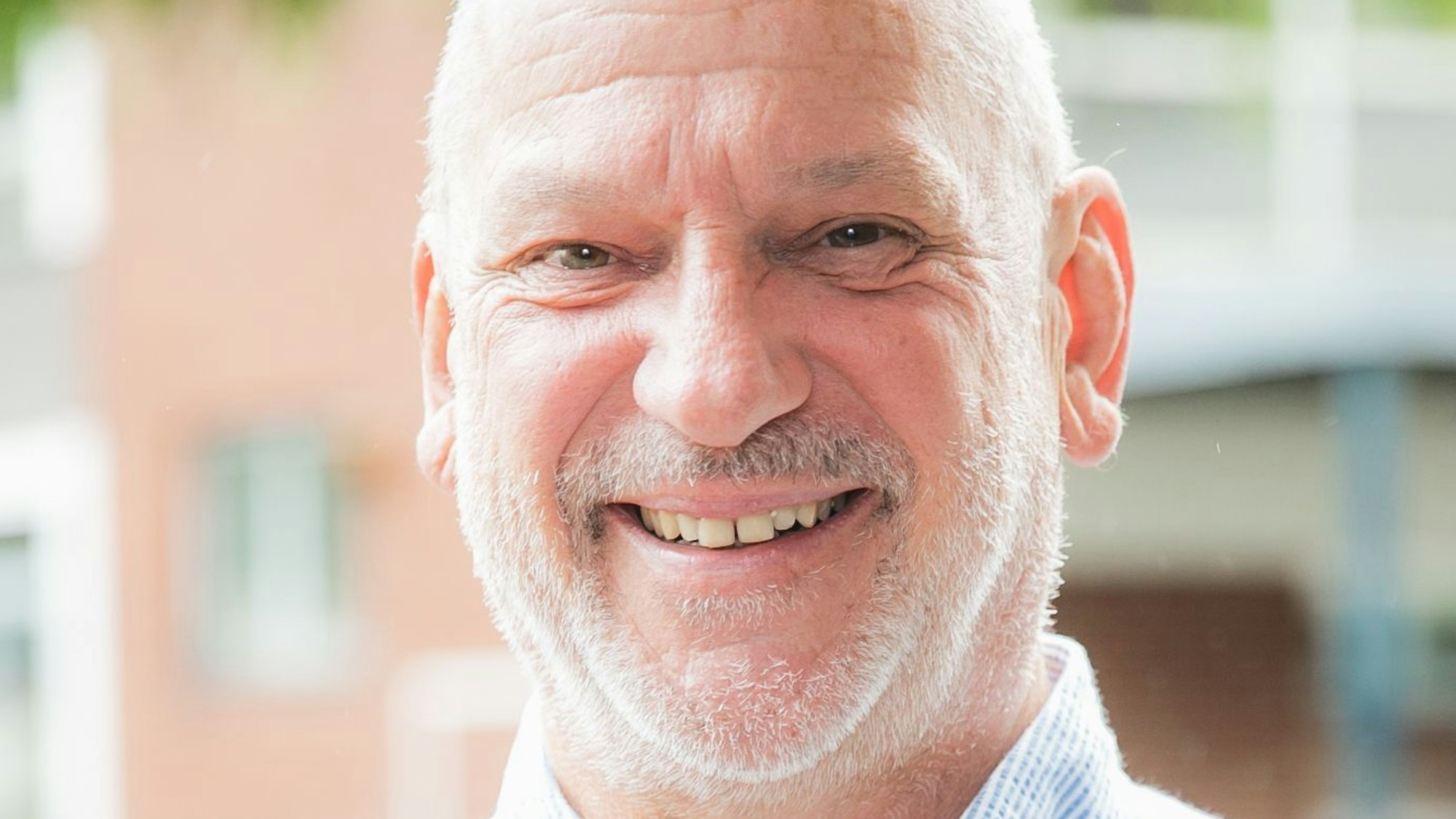 Der verstorbene Schulleiter lächelt in die Kamera.