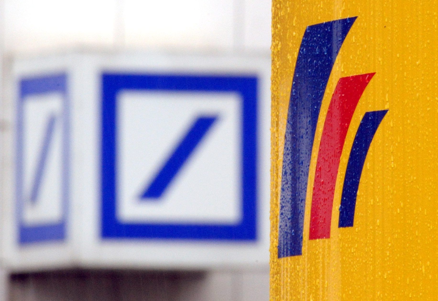 ARCHIV - 12.09.2008, Nordrhein-Westfalen, Bonn: Das Logo der Deutschen Bank hängt gegenüber dem Logo der Postbank. (zu dpa: «Alarmanlage defekt - Filialen von Deutscher und Postbank zeitweise zu») Foto: Federico Gambarini/dpa +++ dpa-Bildfunk +++