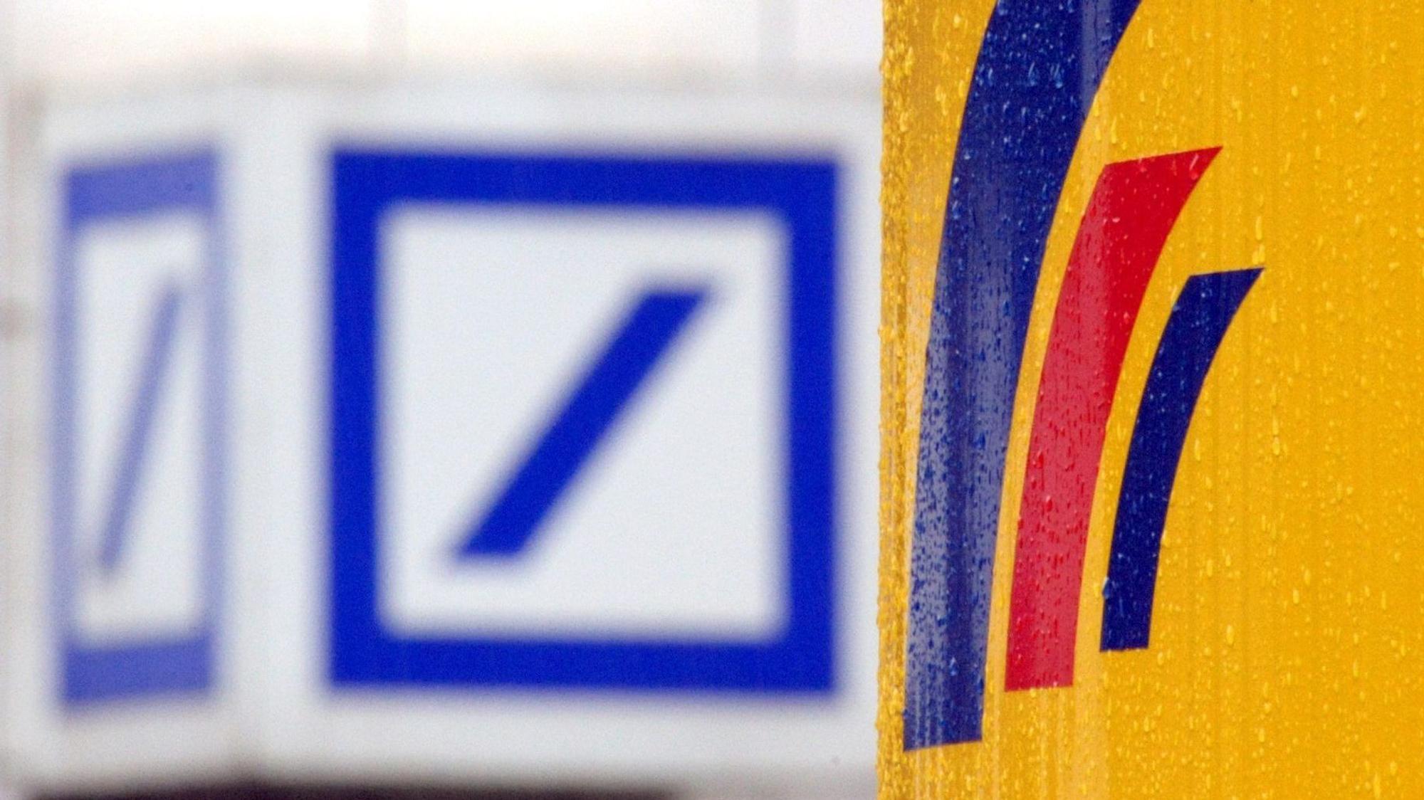 ARCHIV - 12.09.2008, Nordrhein-Westfalen, Bonn: Das Logo der Deutschen Bank hängt gegenüber dem Logo der Postbank. (zu dpa: «Alarmanlage defekt - Filialen von Deutscher und Postbank zeitweise zu») Foto: Federico Gambarini/dpa +++ dpa-Bildfunk +++