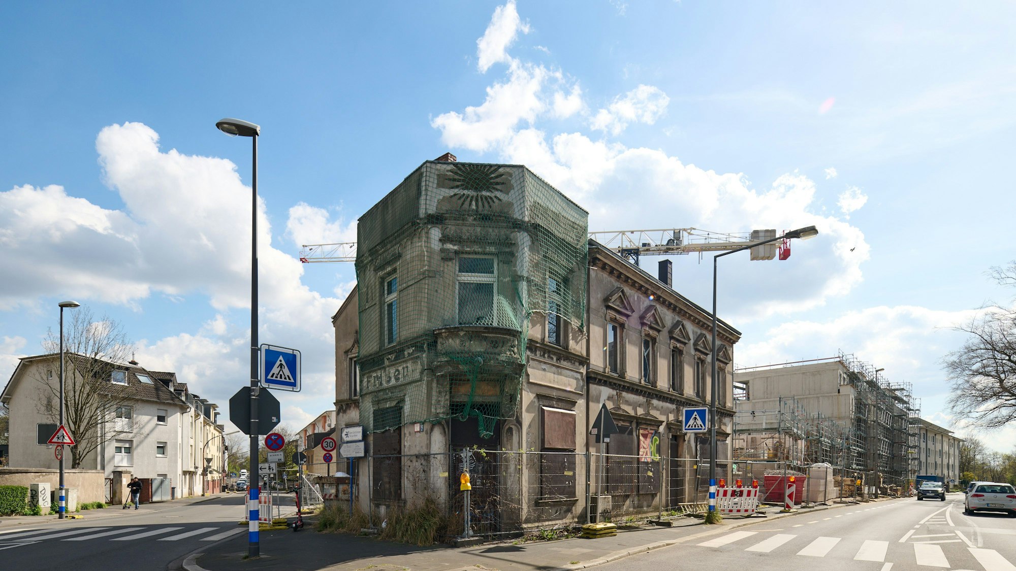 Blick auf ein Eckhaus, das von einem Bauzaun umstellt ist