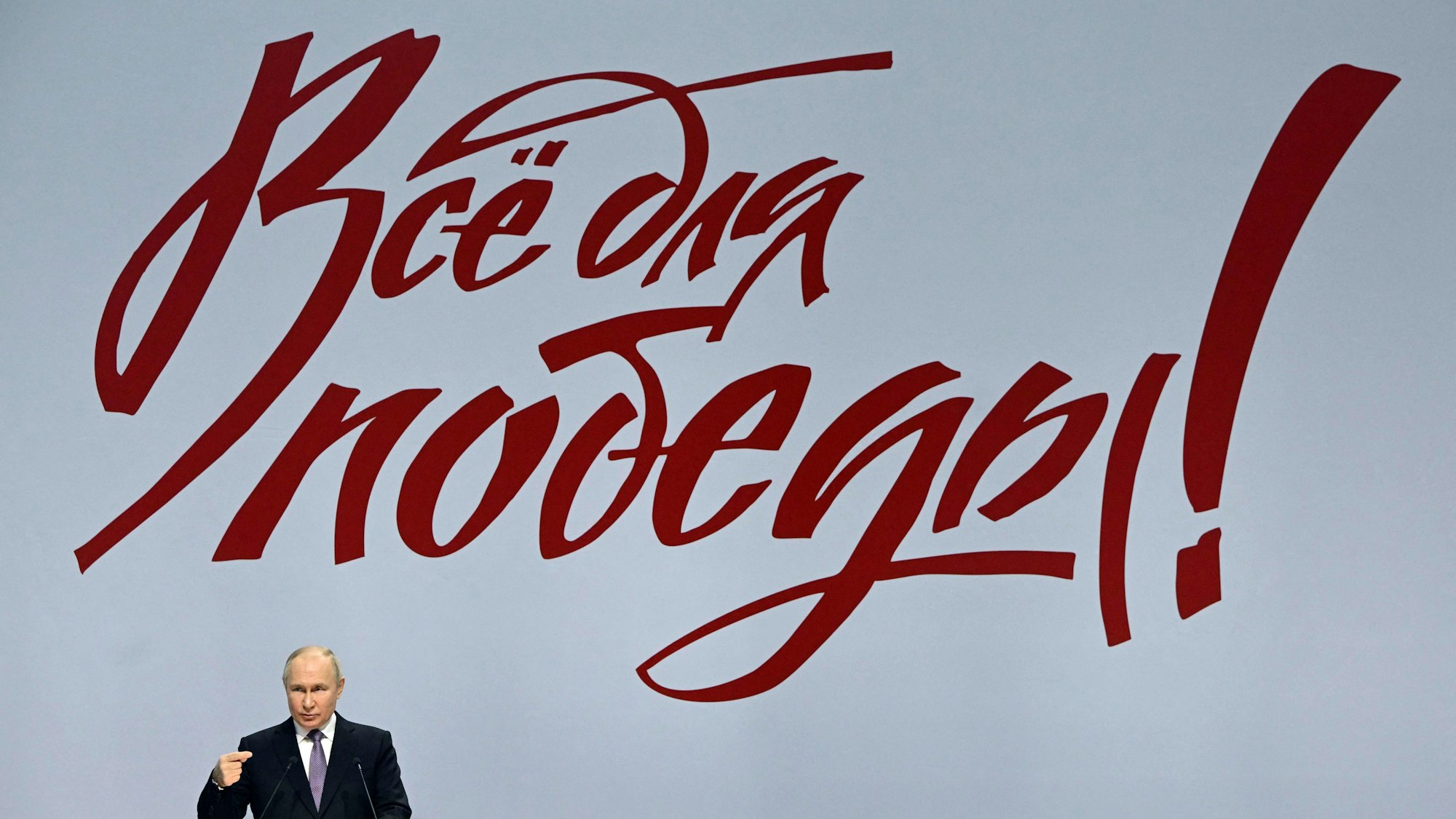 Wladimir Putin bei seiner Rede in Tula. Im Hintergrund ist der Slogan: „Alles für den Sieg!“ zu sehen.