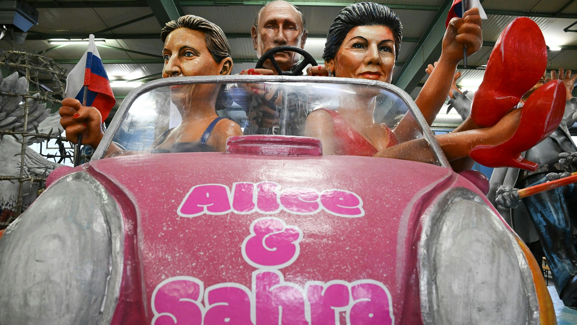 06.02.2024, Rheinland-Pfalz, Mainz: Der russische Präsident Wladimir Putin (M), Alice Weidel (AfD, l) und Sahra Wagenknecht (BSW) werden als ·Barbies und ·Ken·· bei der Vorstellung der Motivwagen für den Mainzer Rosenmontagszug in der Wagenhalle des Mainzer Carneval-Vereins (MCV) präsentiert. Innen- und außenpolitischen Themen dienen als Vorlage für die närrischen Motivwagen, die am 12. Februar im närrischen Lindwurm durch die Landeshauptstadt rollen. (zu dpa: «Scholz fährt als Schiffbrüchiger beim Mainzer Rosenmontagszug mit») Foto: Arne Dedert/dpa +++ dpa-Bildfunk +++