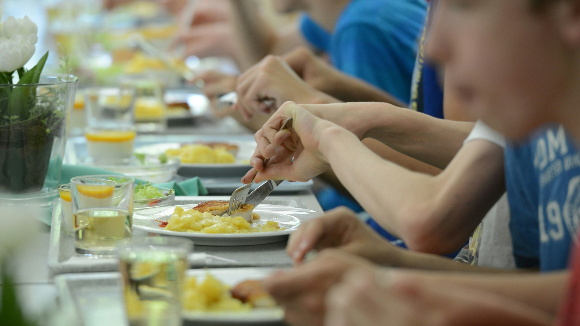 Schüler nehmen ihr Mittagsessen in der Mensa eines Gymnasiums ein.