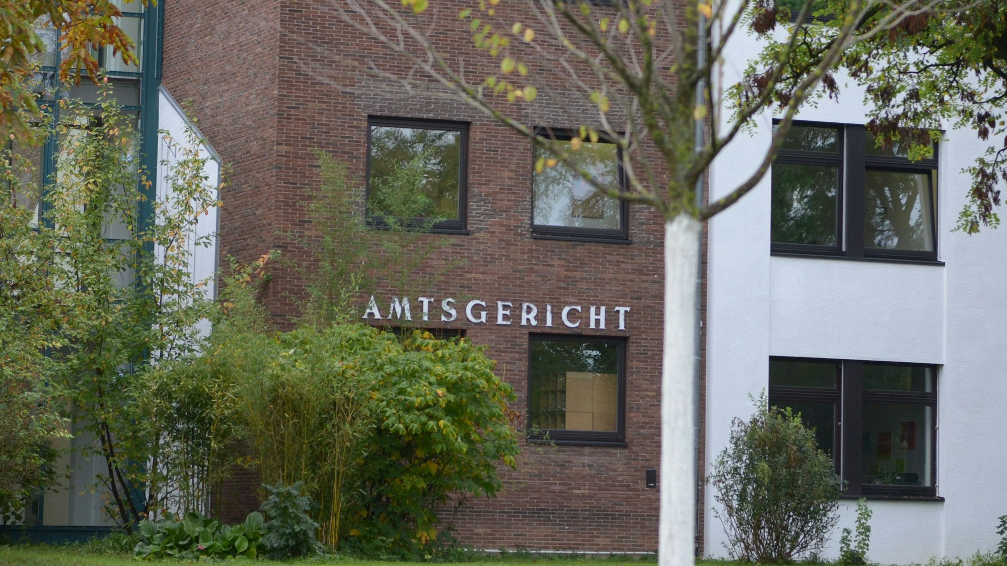 Das Amtsgerichtsgebäude in Euskirchen mit Bäumen im Vordergrund.