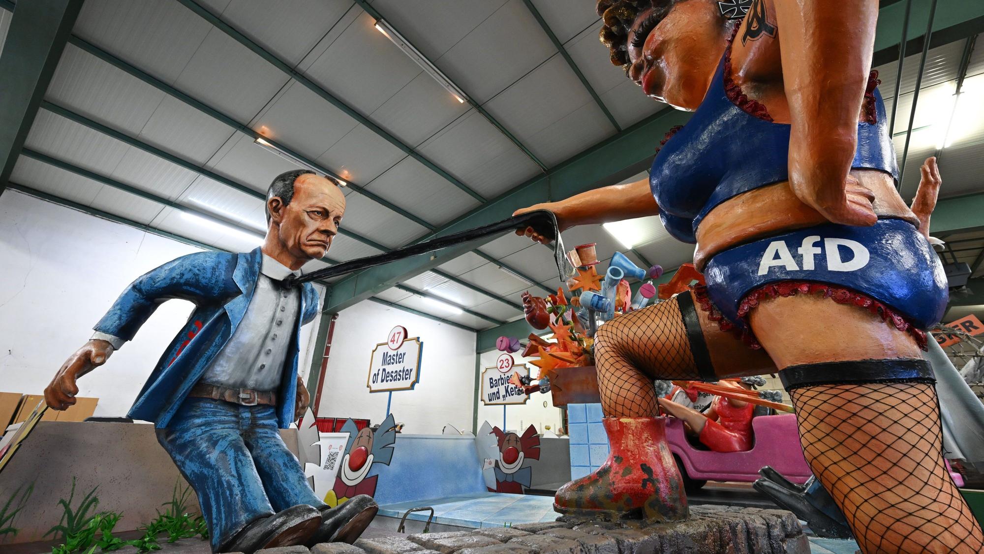 06.02.2024, Rheinland-Pfalz, Mainz: Eine AfD-Frauenfigur krallt sich den CDU-Bundesvorsitzenden Friedrich Merz bei der Vorstellung der Motivwagen für den Mainzer Rosenmontagszug in der Wagenhalle des Mainzer Carneval-Vereins (MCV) unter dem Titel ·Wie wär's mit uns ?· als Koalitionspartner. Innen- und außenpolitischen Themen dienen als Vorlage für die närrischen Motivwagen, die am 12. Februar im närrischen Lindwurm durch die Landeshauptstadt rollen. Foto: Arne Dedert/dpa +++ dpa-Bildfunk +++