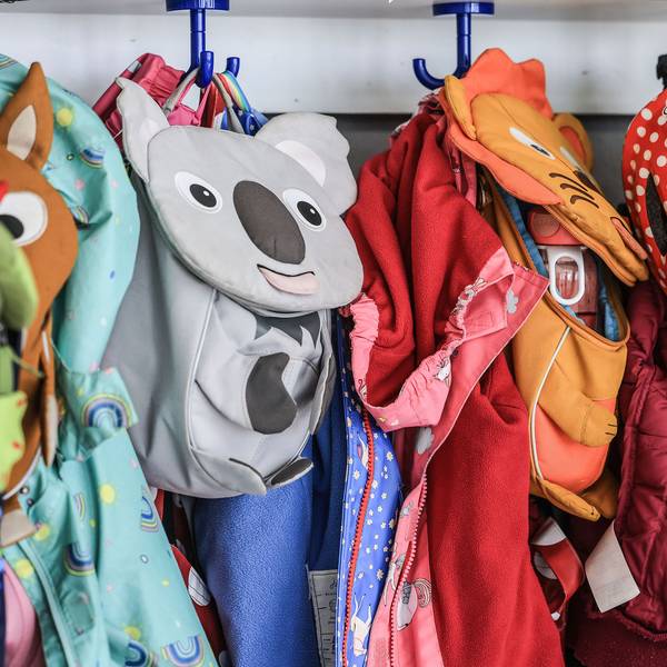 Garderobe und Taschen von Kindern hängen im Flur einer Kindertagesstätte.