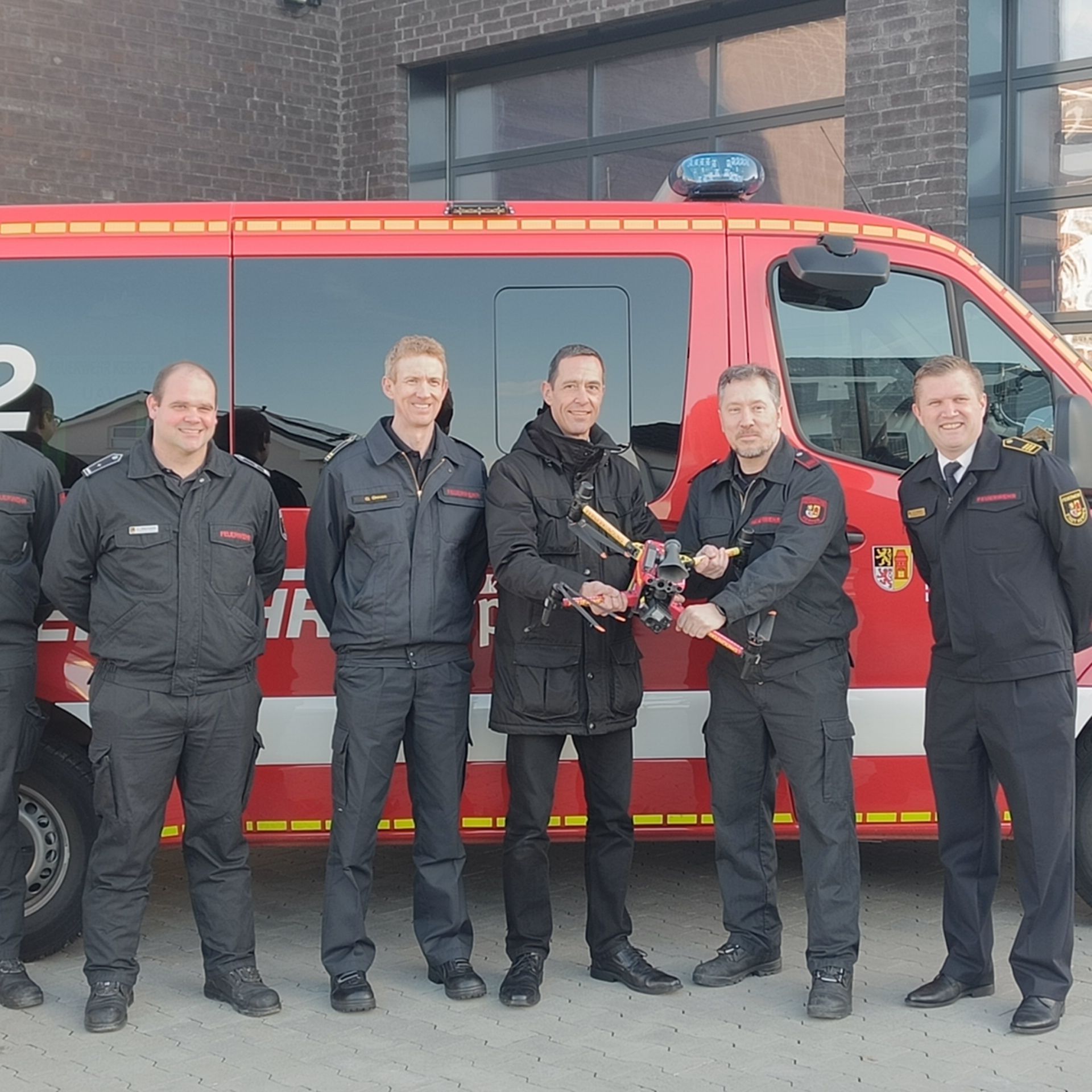 Auf dem Foto sind Kerpens Bürgermeister Dieter Spürck und Feuerwehrleute mit einer Drohne zu sehen.