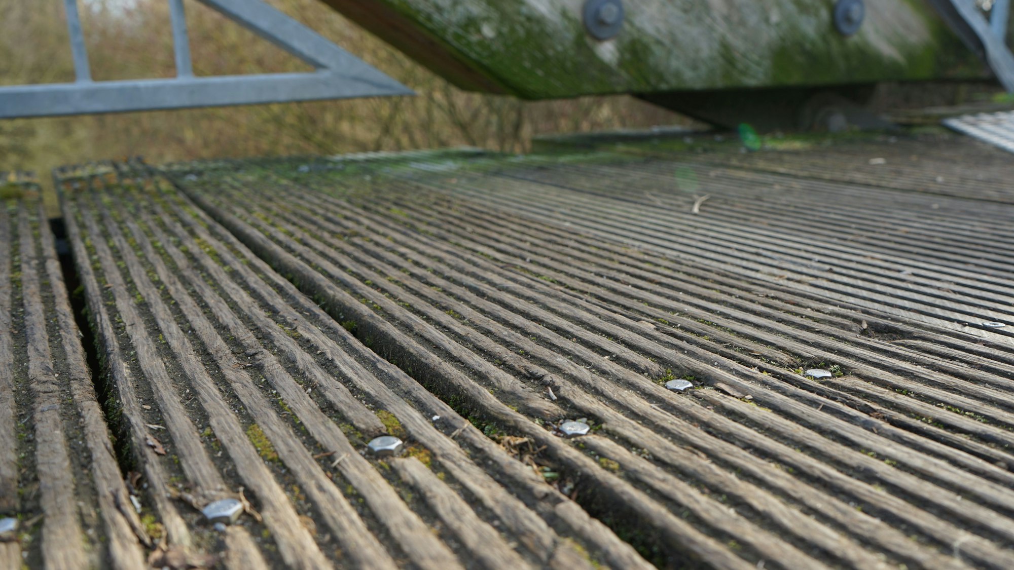 Die Holzlatten der Brücke splittern, auf ihnen wächst Moos.