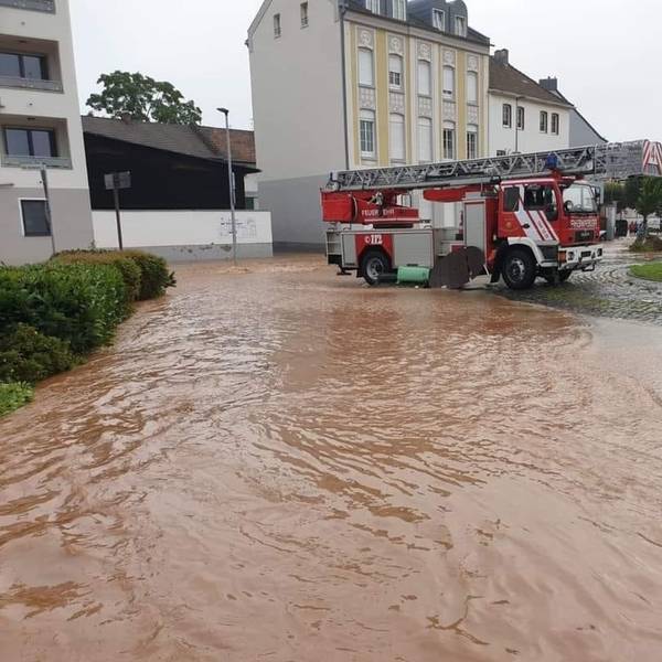 Die Euskirchener Drehleiter steht nach der Flut 2021 am Europakreisel in Euskirchen. Im Vordergrund die noch überschwemmte Straße.