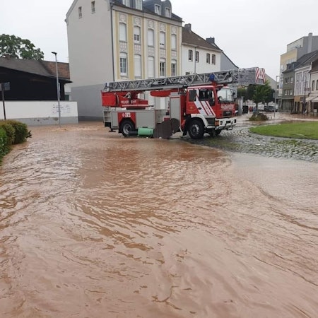 Die Euskirchener Drehleiter steht nach der Flut 2021 am Europakreisel in Euskirchen. Im Vordergrund die noch überschwemmte Straße.