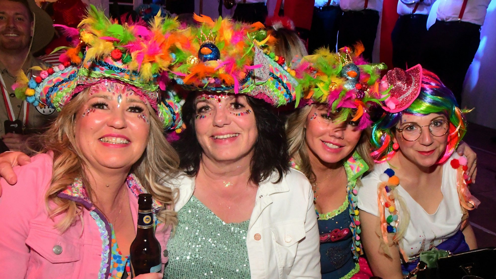 Vier kostümierte Frauen mit buntem Kopfschmuck haben sich zum Foto aufgestellt.