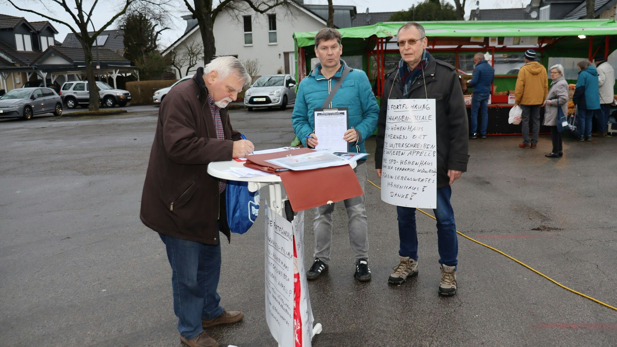 Dominik Zier (2.v.l.) und Herbert Mück (r.) sammelten Unterschriften für den Erhalt der Sparkassenfiliale Höhenhaus. Foto: Uwe Schäfer