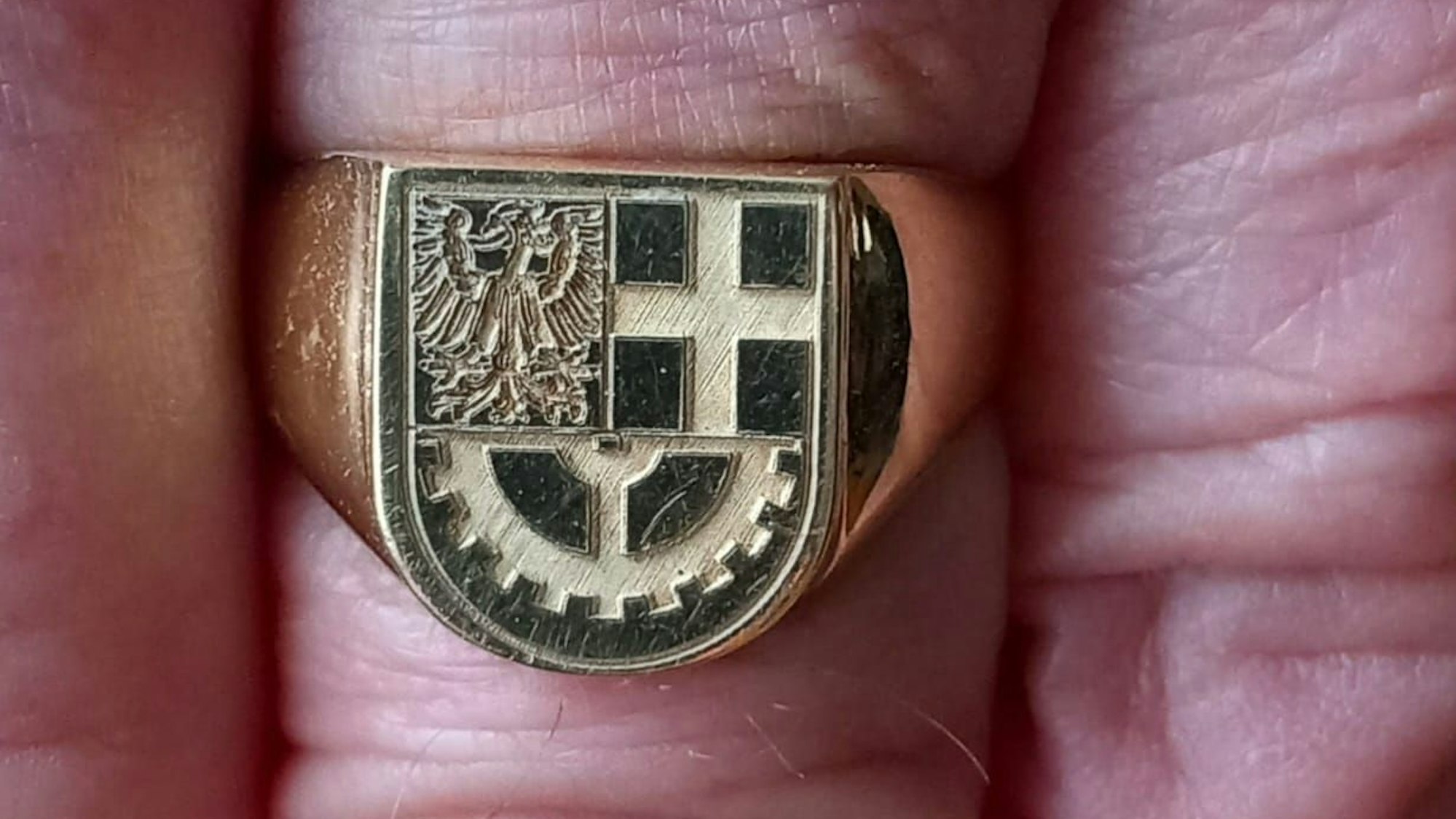 Ein Ring mit dem Hürther Stadtwappen an einem Finger.