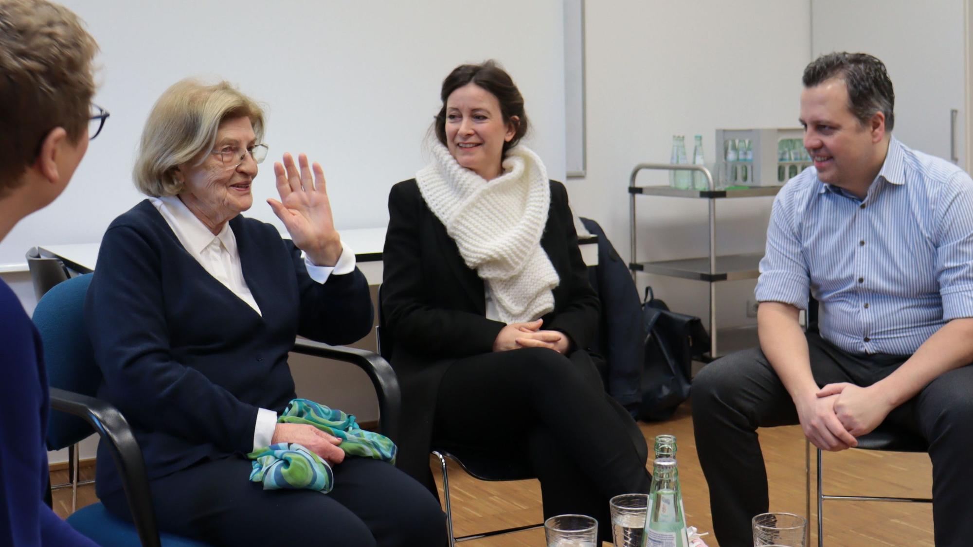 Eva Szepesi und einige ihrer Zuhörerinnen und Zuhörer sitzen auf Stühlen nebeneinander.