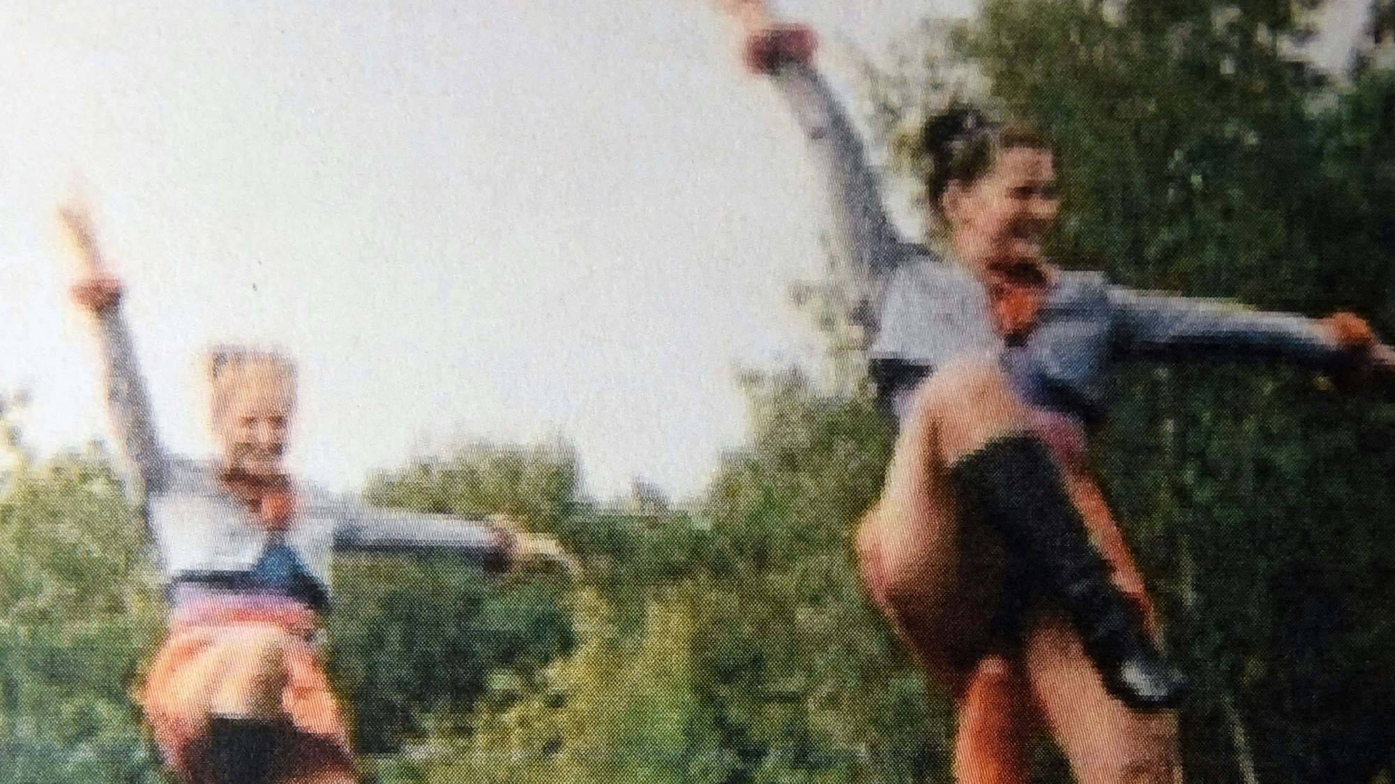 Ein altes Foto zeigt zwei Tänzerinnen, die von Männern hochgehoben werden und in eine Menge winken.