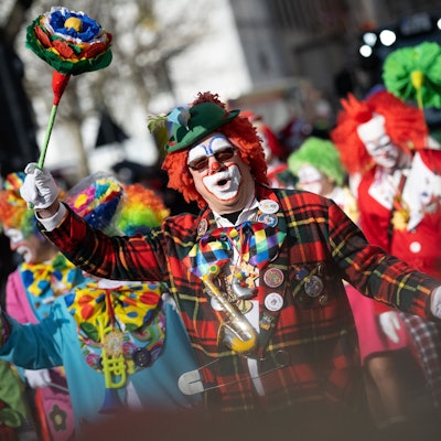 Ein Clown jubelt während des Rosenmontagsumzuges.