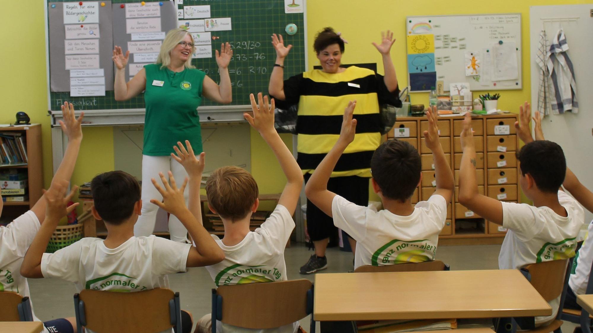 Auf dem Foto sind zwei Lehrerinnen der Johannes-Gutenberg-Grundschule Wesseling und Schüler in einem Klassenraum zu sehen.