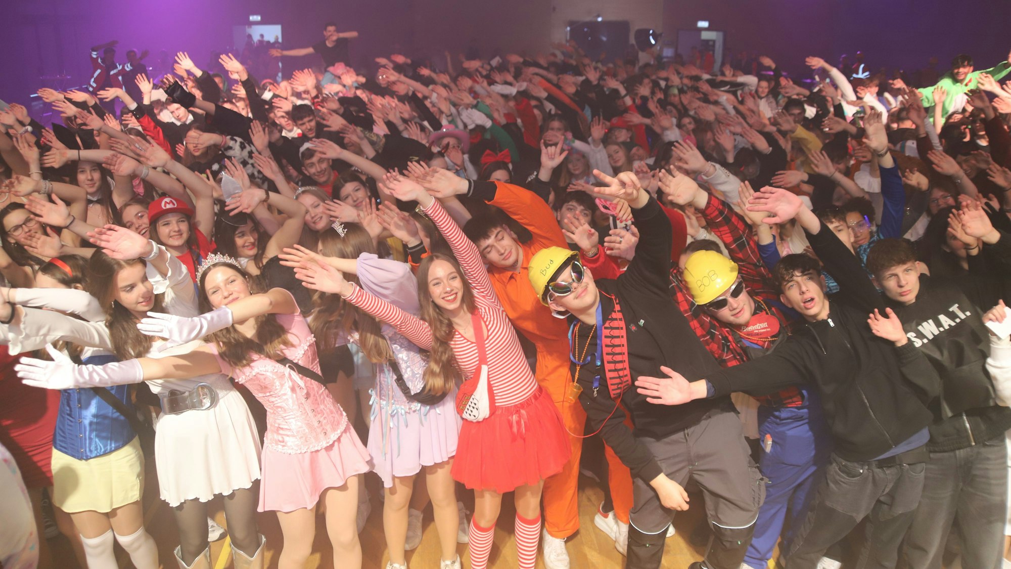 Verkleidete Jugendliche werfen die Arme in die Luft.