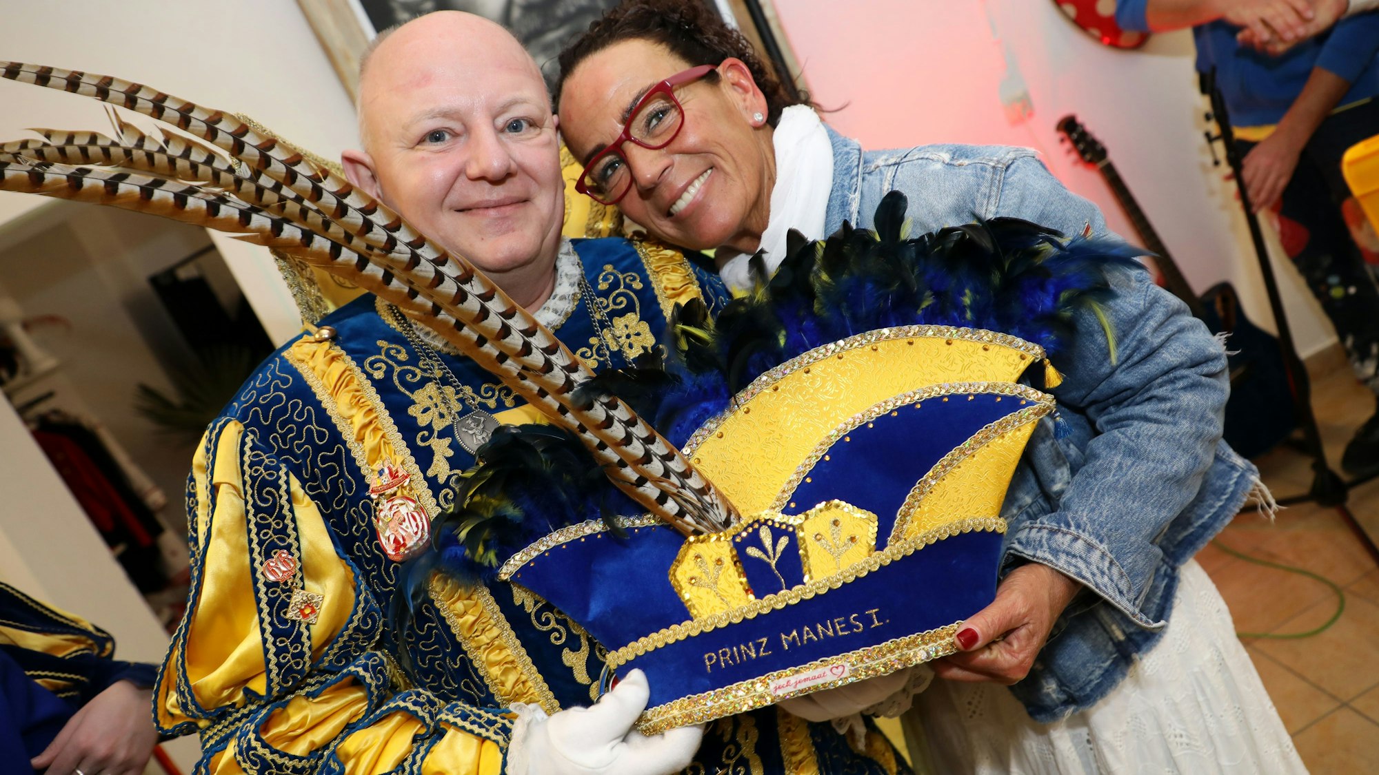 Prinz Manes I. aus dem Eikamper Dreigestirn und Heike Funk halten eine Prinzenkappe in den Händen.