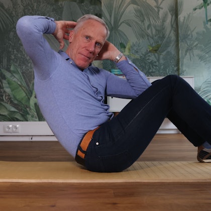 Ingo Froböse zeigt eine Sportübung auf der Matte.