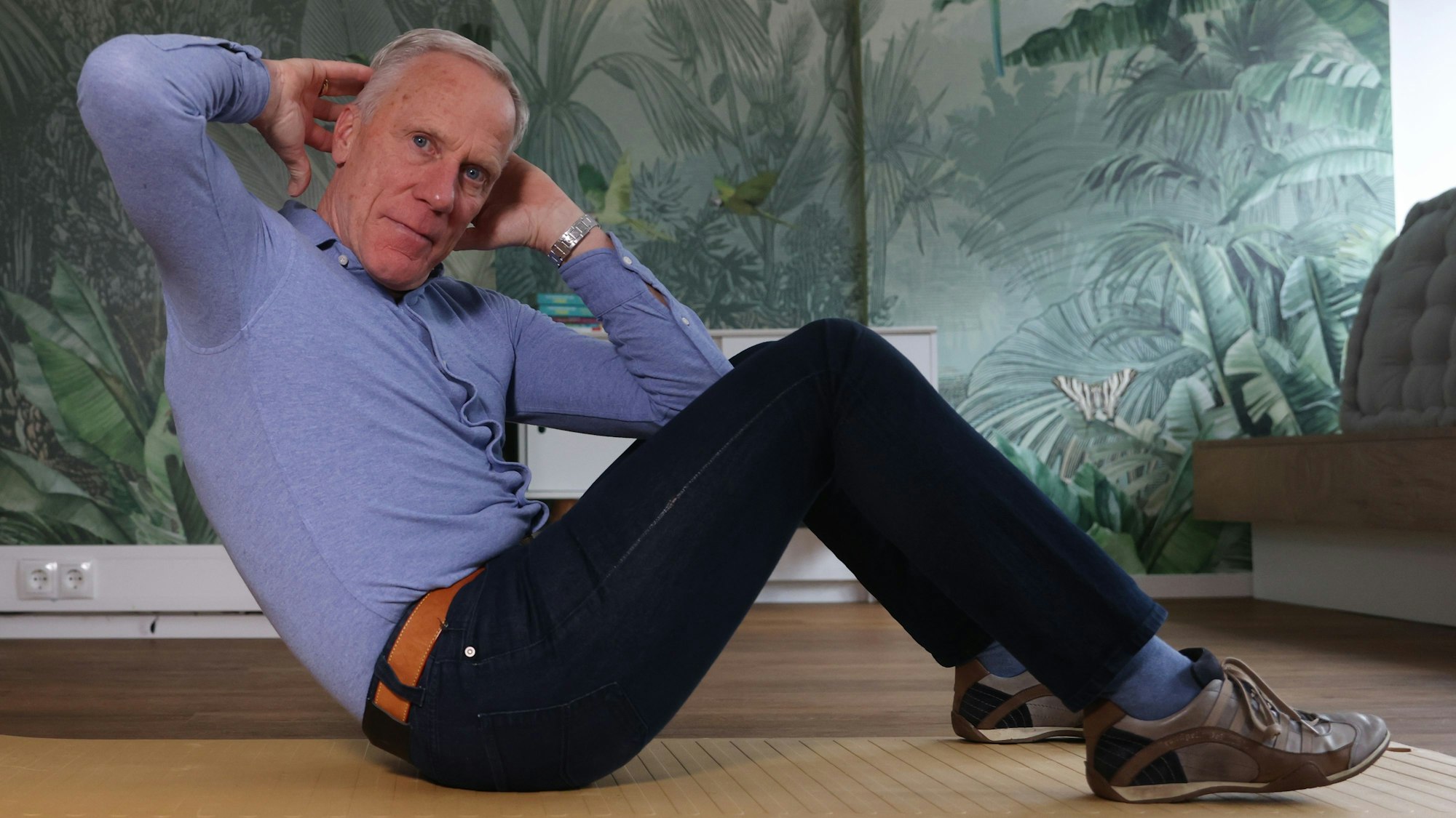 Ingo Froböse zeigt eine Sportübung auf der Matte.