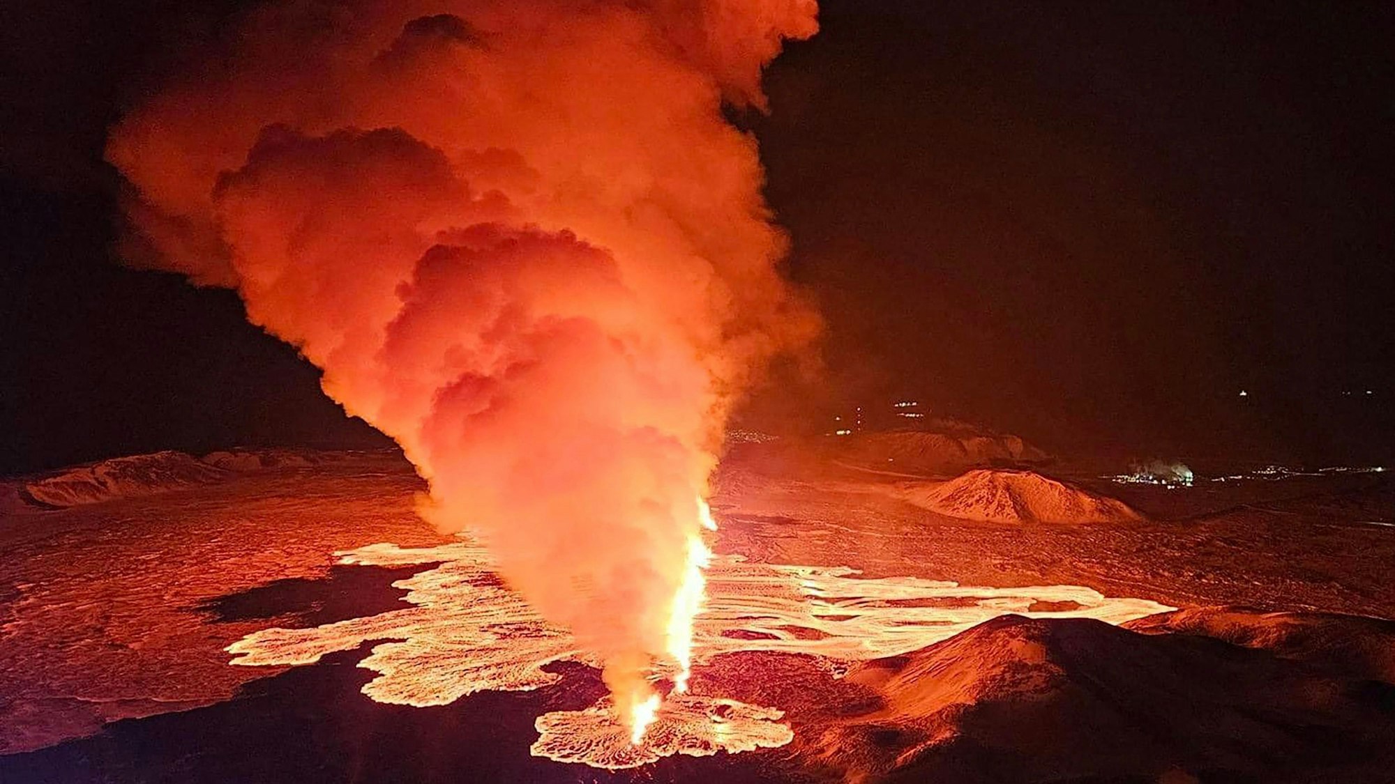Rauchschwaden und fließende Lava strömen aus einer neuen Spalte. Das Foto wurde während des neuen Vulkanausbruchs am Rande der evakuierten Stadt Grindavik im Westen Islands aufgenommen wurde.