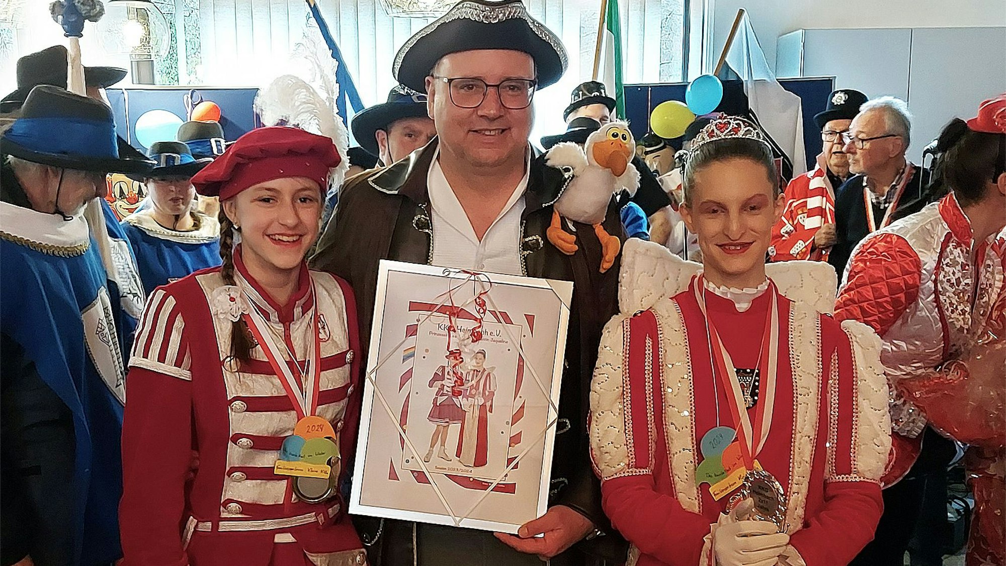 Kinderprinzessin Lea II. steht neben Bürgermeister Jochen Weiler, der ein Erinnerungsfoto in den Händen hält.