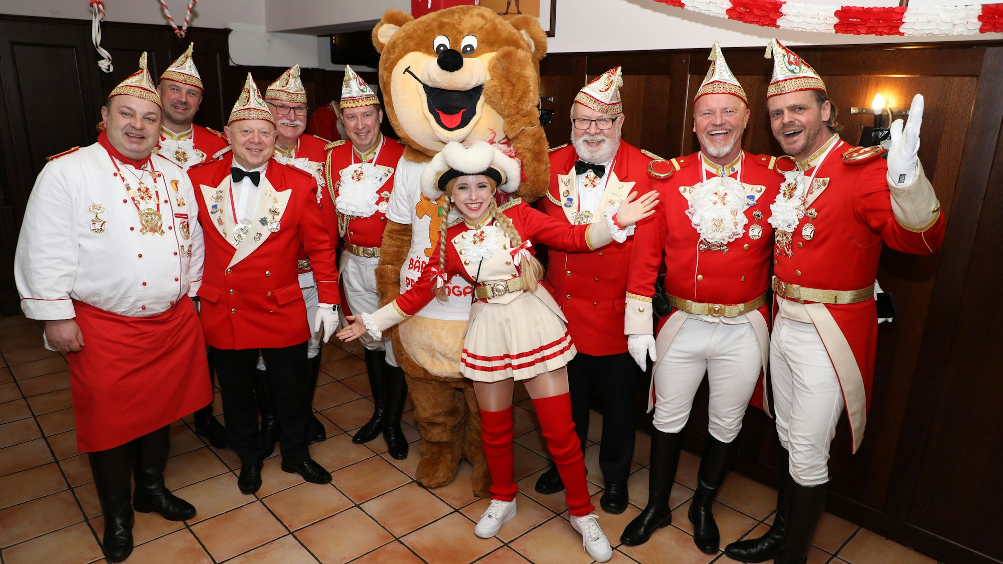 Prinzengardisten haben sich mit Tanzmarie und Bärenmaskottchen zum Gruppenbild aufgestellt.