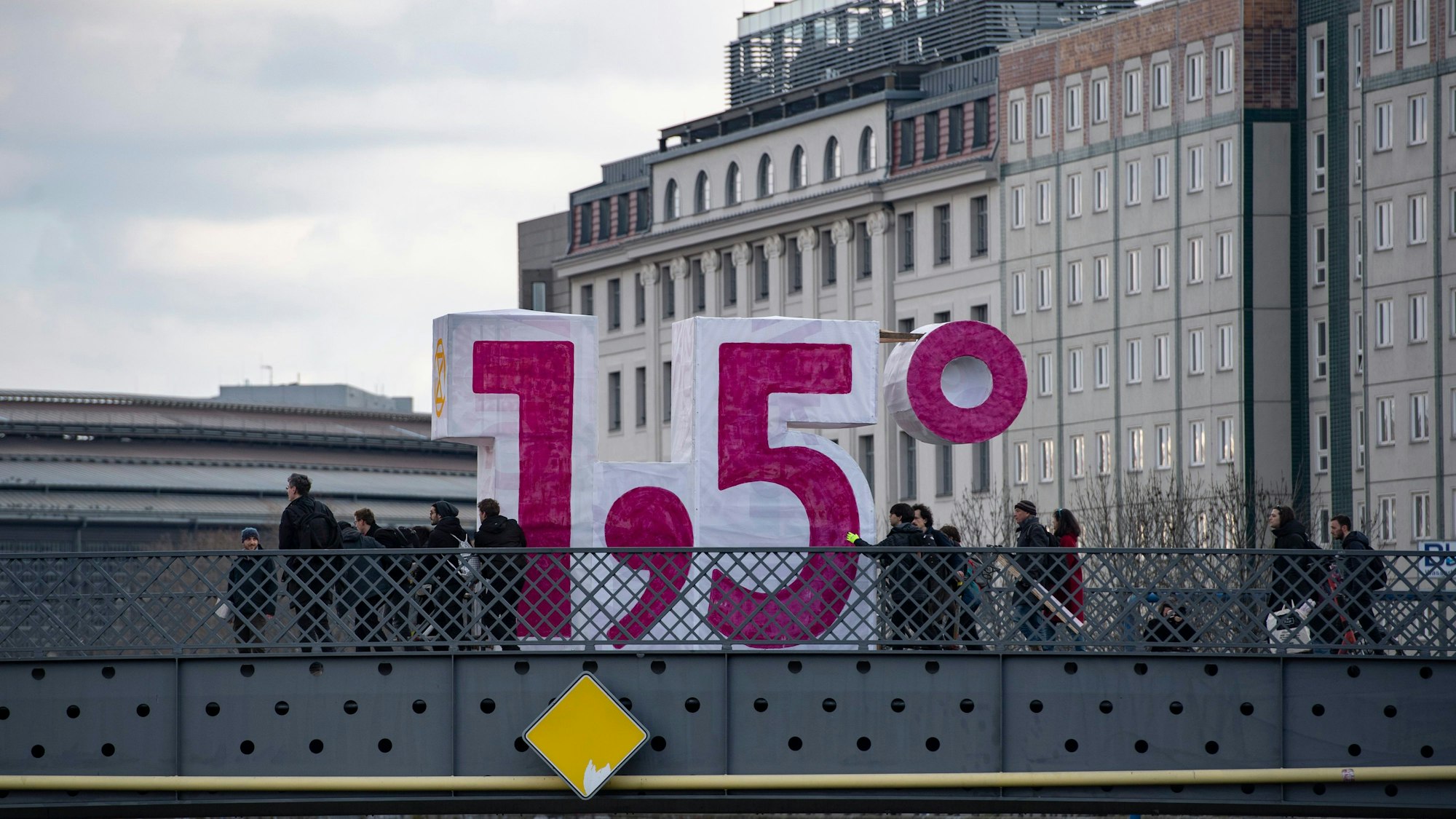 ARCHIV - 05.03.2022, Berlin: Eine übergroße Zahl haben Anhänger und Mitglieder der Umweltschutzbewegung Extinction Rebellion auf einer Brücke aufgestellt. Die Erderwärmung bei 1,5 Grad zu stoppen, ist ein Pariser Klimaziel. Die Bertelsmann Stiftung hat Unternehmen befragt, wie es um die eigene Ziele aussieht. (zu dpa: «Umfrage: Viele Unternehmen kennen eigenen CO2-Fußabdruck») Foto: Paul Zinken/dpa +++ dpa-Bildfunk +++